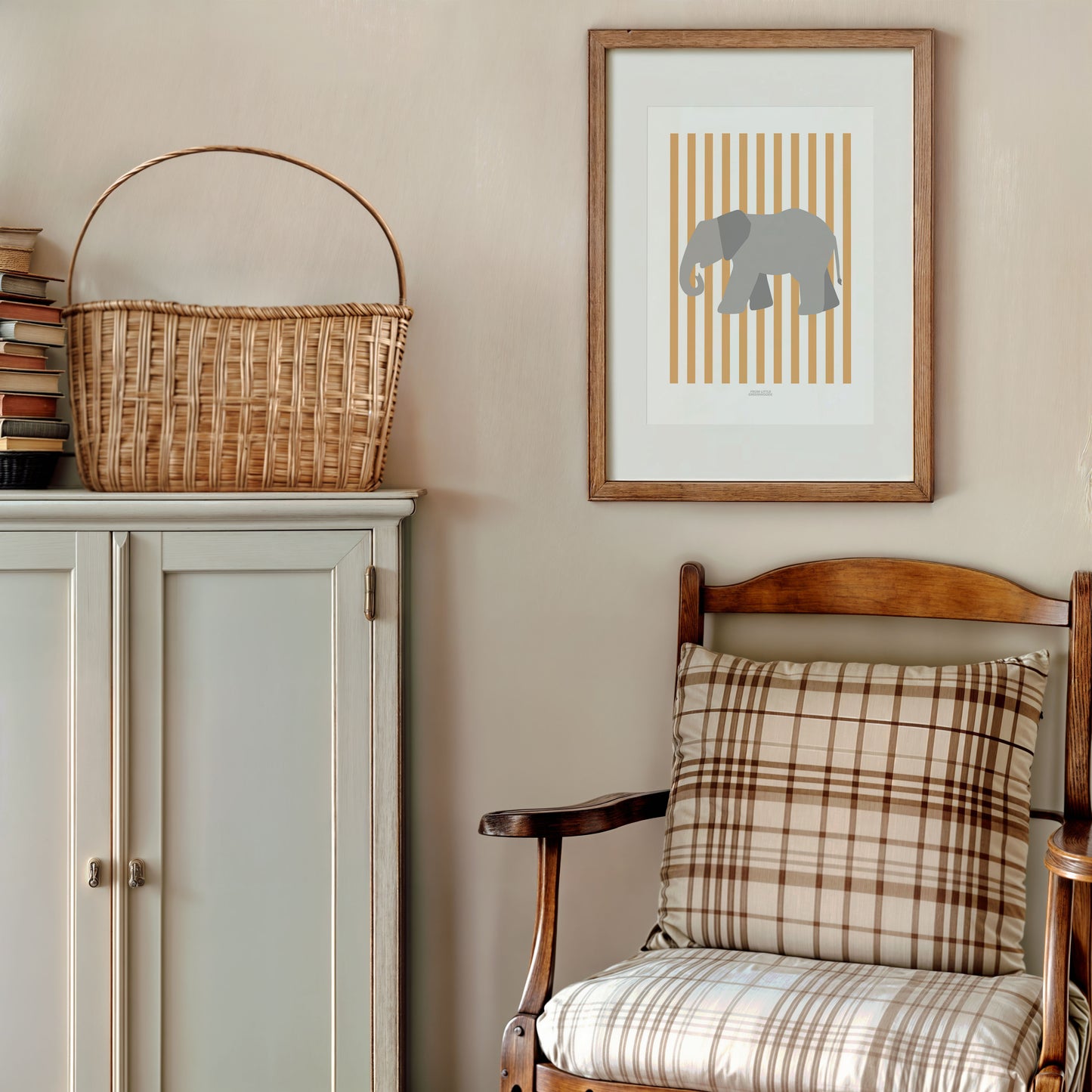 Nursery room with a cabinet, basket, chair, and framed elephant print on the wall.