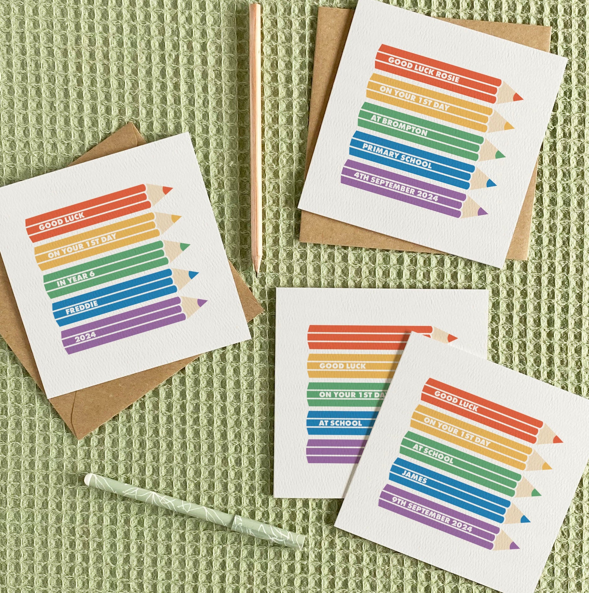Set of greeting cards with rainbow pencil design on a textured green surface
