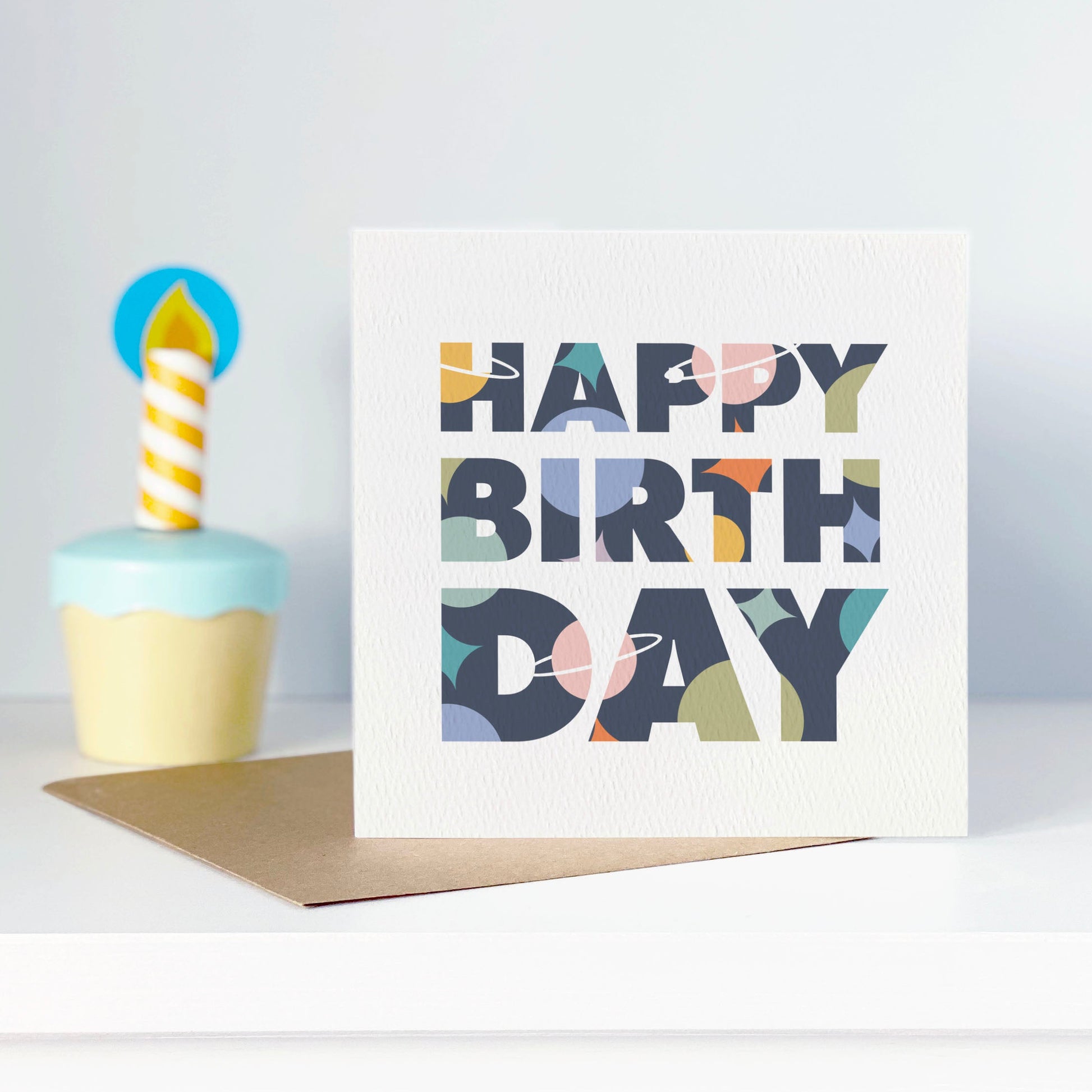 Greeting card with 'Happy Birthday' text and a colorful cupcake illustration on a white background