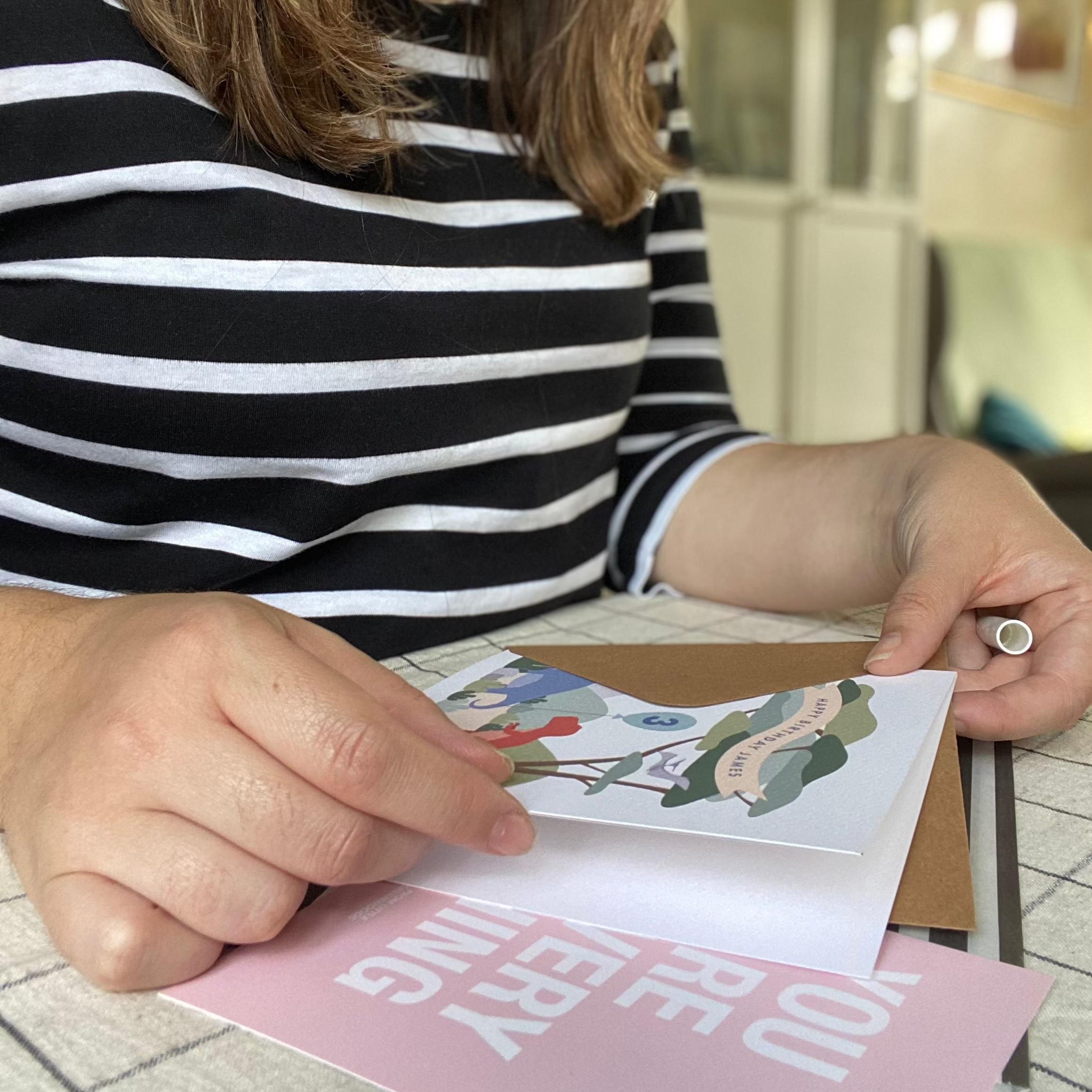 Person holding a printed card with a colorful design and text.